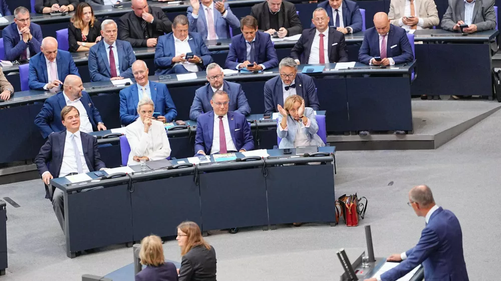 Federal chairwoman and parliamentary group leader of the AfD Alice Weidel, sitting in first row, centre left, looks at German Chancellor Friedrich Merz as he speaks during the general debate as part of the budget deliberations in the Bundestag, in Berlin, Wednesday Sept. 9, 2026. (Michael Kappeler/dpa via AP)