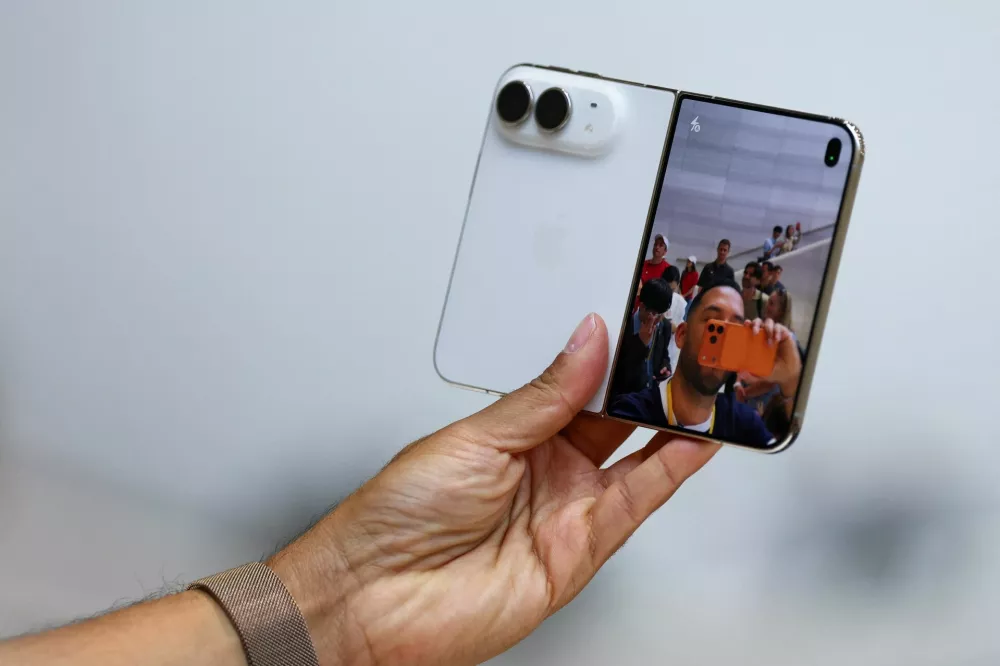 A person holds the new foldable iPhone Duo during Apple's event at the Steve Jobs Theater in Cupertino, California, U.S. September 9, 2026. REUTERS/Carlos Barria