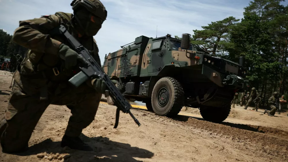 A Polish soldier kneels next to a military vehicle during the Bursztynowy Obronca-26 (Amber Defender-26) military exercise at the training ground in Klusy, Poland, June 24, 2026. REUTERS/Kacper Pempel