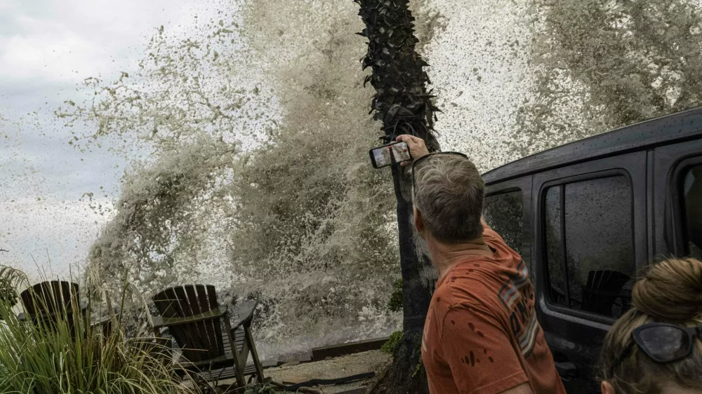 A Long Beach resident observes a crashing wave overtaking the sea wall. Hurricane Marie makes landfall in Long Beach, California.