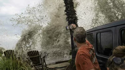 A Long Beach resident observes a crashing wave overtaking the sea wall. Hurricane Marie makes landfall in Long Beach, California.
