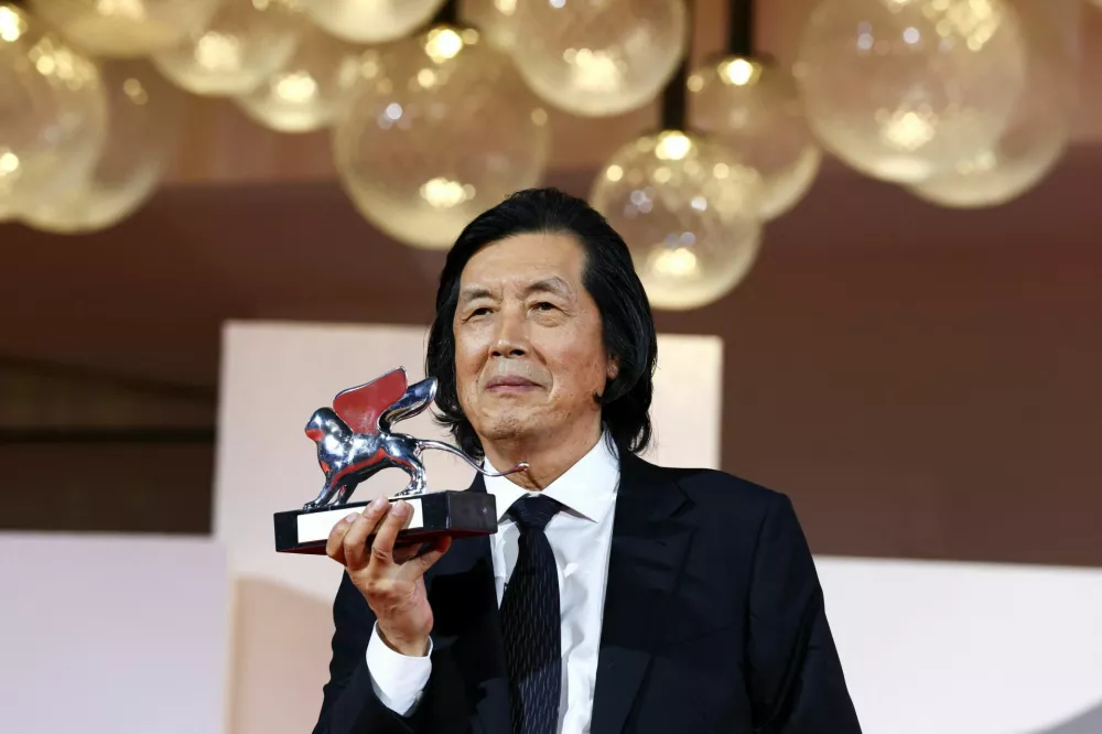 Director Lee Chang-Dong poses with the Silver Lion Grand Jury Prize for the movie "Possible Love" during the closing ceremony of the 83rd Venice International Film Festival, Italy, September 12, 2026. REUTERS/Yves Herman