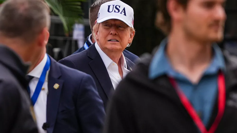 U.S. President Donald Trump, center, attends the Irish Open golf tournament at Trump International Golf Links in Doonbeg, Ireland, Sunday, Sept. 13, 2026. (AP Photo/Julia Demaree Nikhinson)