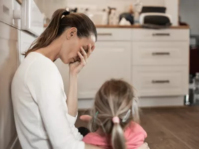 Tired stressed out mother with daughter.