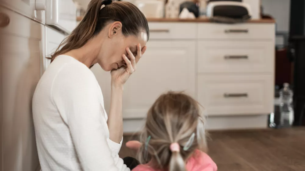 Tired stressed out mother with daughter.