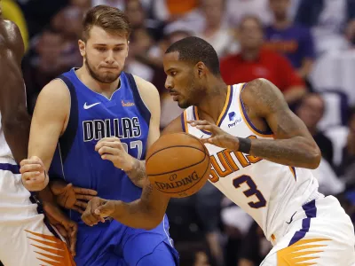 Phoenix Suns forward Trevor Ariza (3) dries past Dallas Mavericks guard Luka Doncic during the first half of an NBA basketball game, Wednesday, Oct. 17, 2018, in Phoenix. (AP Photo/Matt York)