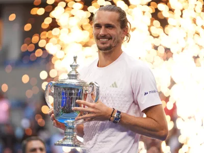 Alexander Zverev, of Germany, holds his trophy after winning the men's singles final of the U.S. Open tennis championships against Ben Shelton, of the United States, Sunday, Sept. 13, 2026, in New York. (AP Photo/Frank Franklin II)