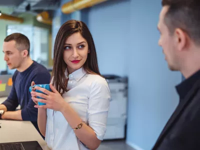 Girl looking at her colleague with love in her eyes while he is talking