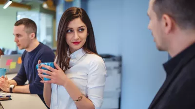 Girl looking at her colleague with love in her eyes while he is talking