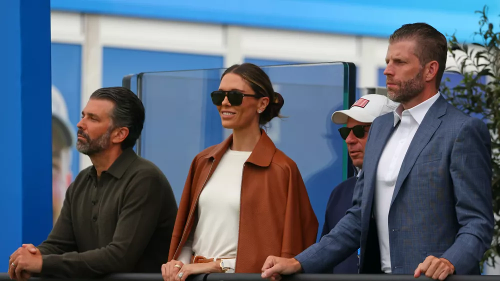 U.S. President Donald Trump's sons Eric Trump, right, Donald Trump Jr, and his wife Bettina watch the play at the Irish Open at the Trump International Golf Links course in Doonbeg, Ireland, Sunday, Sept. 13, 2026.(AP Photo/Peter Morrison)