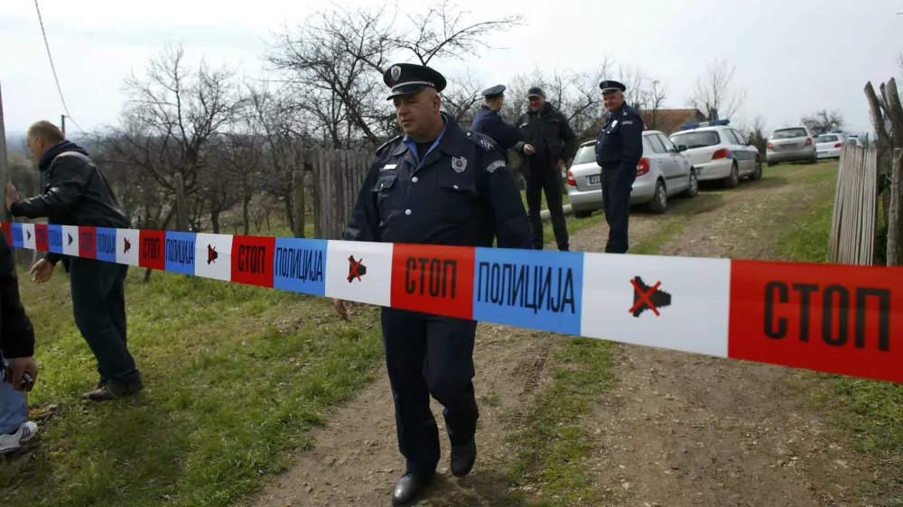 A policeman stands guard in the village of Velika Ivanca, about 40 km (25 miles) southwest of Belgrade April 9, 2013. A gunman shot dead 13 people, including his mother and son, in an early-morning rampage through a small Serbian village southwest of the capital Belgrade on Tuesday, authorities said. Those killed included a two-year-old child. The gunman, identified by police as Ljubisa Bogdanovic - a war veteran born in 1953 - also shot his wife before turning the gun on himself. Both were in critical condition in hospital, police said.  REUTERS/Marko Djurica (SERBIA - Tags: CRIME LAW)