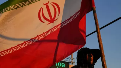 A woman holds an Iranian flag as part of a pro-government campaign in downtown Tehran, Tuesday, Sept. 15, 2026. (AP Photo/Vahid Salemi)