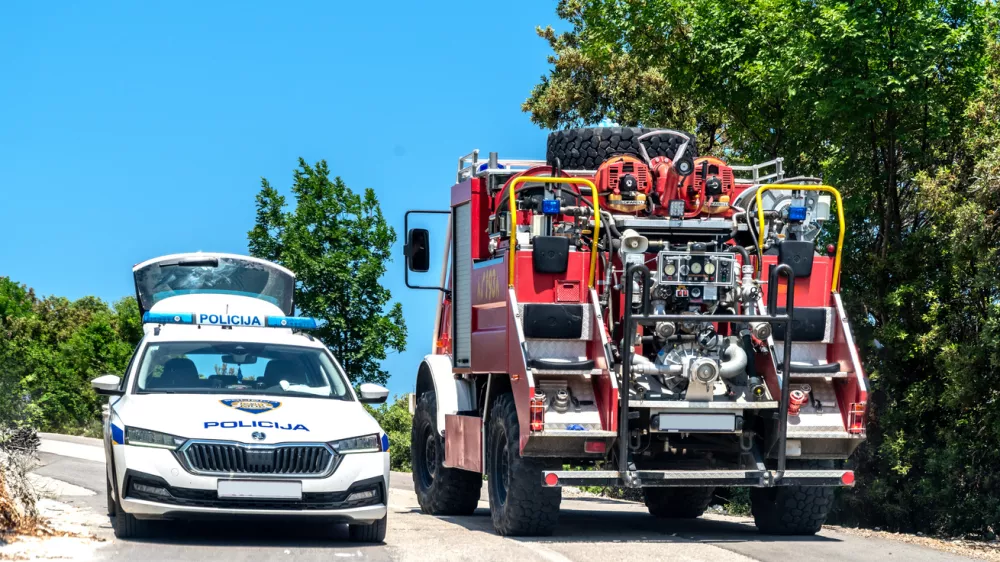 Labin,Croatia, 2023: Police car (Policija) and fire truck (vatrogasci) on a country road near Labin