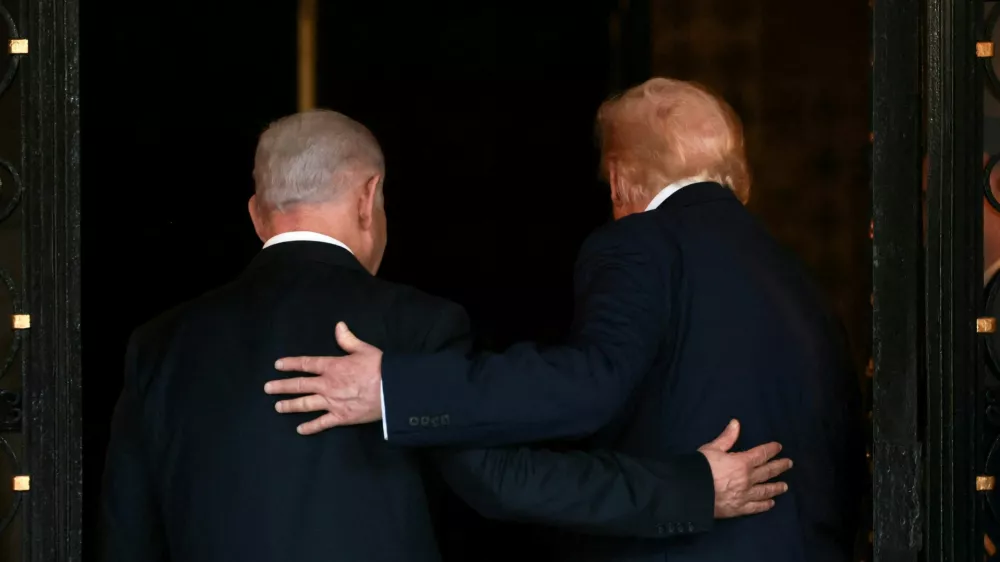 FILE PHOTO: U.S. President Donald Trump and Israeli Prime Minister Benjamin Netanyahu embrace as they walk into Trump's Mar-a-Lago club in Palm Beach, Florida, U.S., December 29, 2025. REUTERS/Jonathan Ernst/File Photo