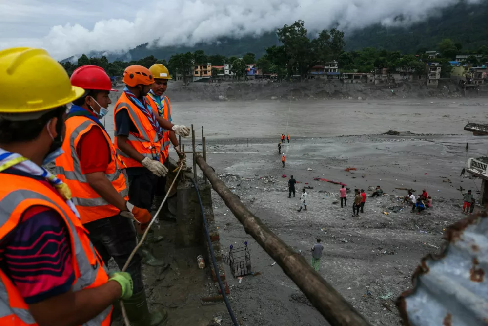 Rescue workers build a makeshift zip line to cross the Trishuli River, following the deadly flash floods and a mudslide, in Devighat, Nuwakot district, Nepal, September 4, 2026. REUTERS/Athit Perawongmetha