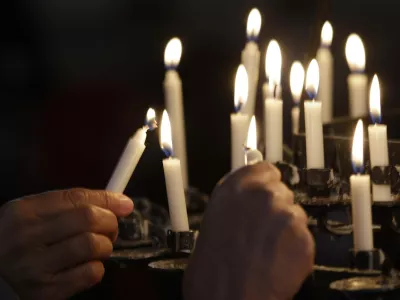 People light candles in the Oslo Cathedral in memory of the victims of Friday's bomb and shooting massacre in Oslo, Norway, Monday, July 25, 2011. The man who has confessed to carrying out a bombing and shooting spree that left 93 people dead in Norway will be held for at least eight weeks, half of that in complete isolation, after a closed hearing in which he said his terror network had two other cells. (AP Photo/Frank Augstein)