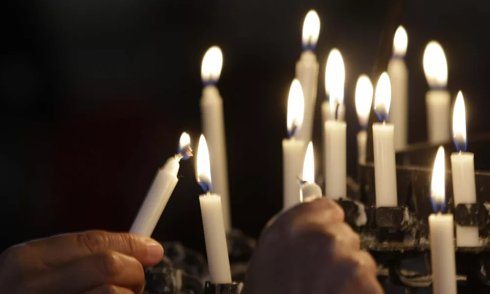 People light candles in the Oslo Cathedral in memory of the victims of Friday's bomb and shooting massacre in Oslo, Norway, Monday, July 25, 2011. The man who has confessed to carrying out a bombing and shooting spree that left 93 people dead in Norway will be held for at least eight weeks, half of that in complete isolation, after a closed hearing in which he said his terror network had two other cells. (AP Photo/Frank Augstein)