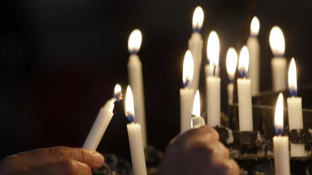 People light candles in the Oslo Cathedral in memory of the victims of Friday's bomb and shooting massacre in Oslo, Norway, Monday, July 25, 2011. The man who has confessed to carrying out a bombing and shooting spree that left 93 people dead in Norway will be held for at least eight weeks, half of that in complete isolation, after a closed hearing in which he said his terror network had two other cells. (AP Photo/Frank Augstein)