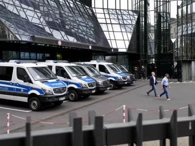 Police officers walk in the backyard of Deutsche Bank headquarters during a raid in Frankfurt, Germany, Thursday, Nov. 29, 2018. (AP Photo/Michael Probst)