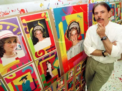FILE PHOTO: Artist Peter Max poses near pictures of Diana, Princess of Wales, in his New York studio, U.S., August 25, 1998. REUTERS/Peter Morgan/File Photo