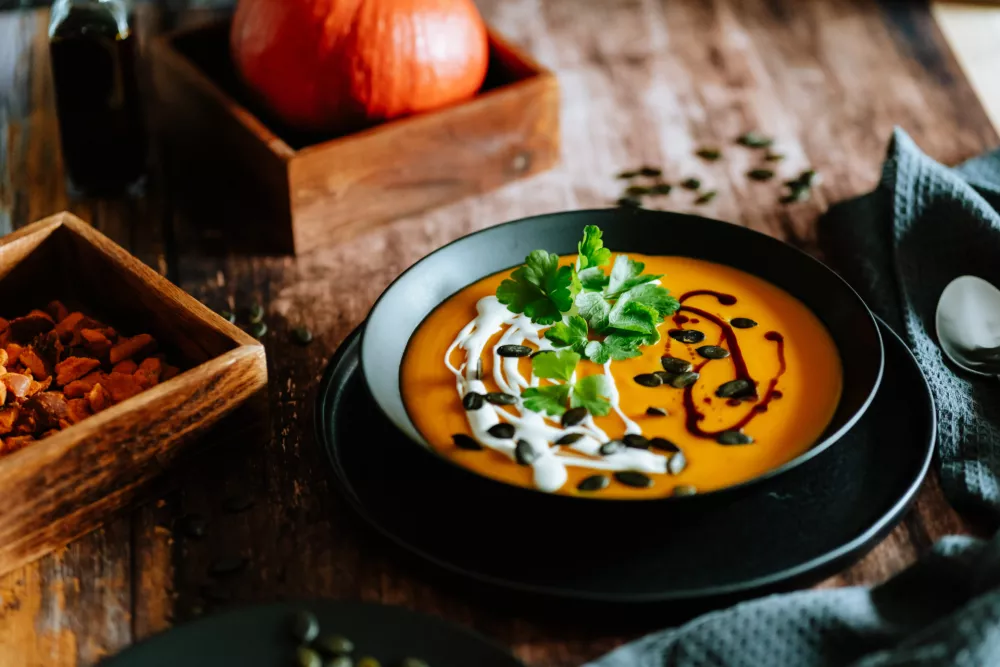 Vegetarian, homemade pumpkin cream soup in a bowl on wooden table. / Foto: Sandra Westermann