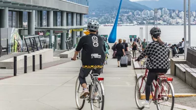 Young active couple in helmets riding on bicycles together on a street of the Vancouver city Canada. Sports, health, activity concept. Travel photo, editorial. July 10,2022