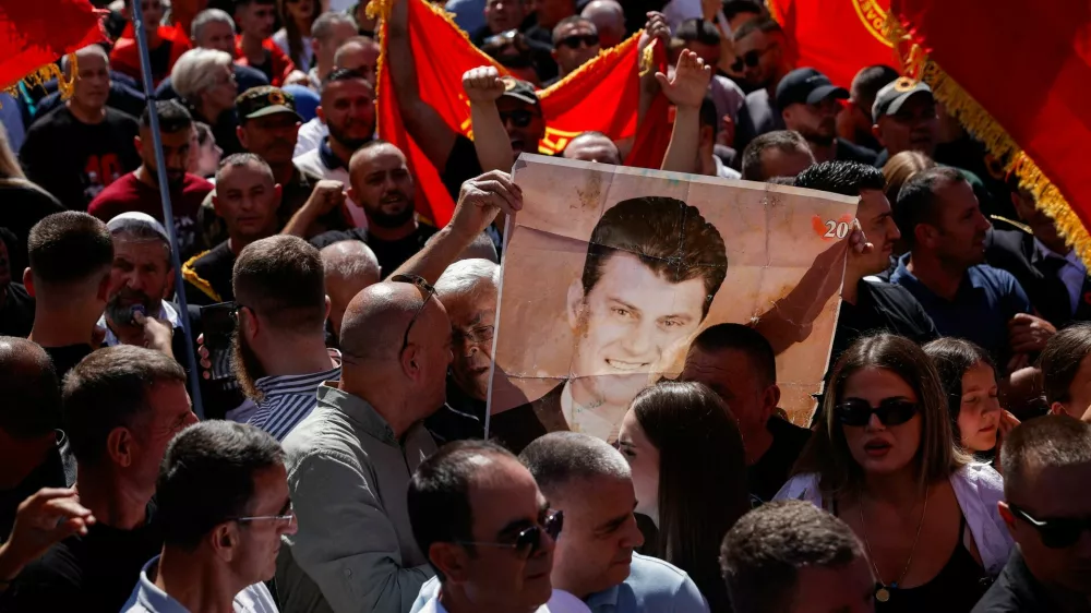 A man holds an image of former Kosovo President Hashim Thaci, during a protest called by war veterans following a Hague court verdict sentencing former Kosovo Liberation Army (KLA) leaders, including Thaci, for war crimes, in Pristina, Kosovo, September 18, 2026. REUTERS/Valdrin Xhemaj