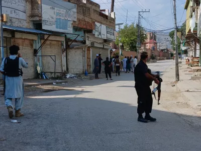 In this photo taken with a smartphone, police officers secure a road leading to the site of a powerful bomb at a mosque in Kohat, Pakistan, Friday, Sept. 18, 2026. (AP Photo/B.S. Gillani)