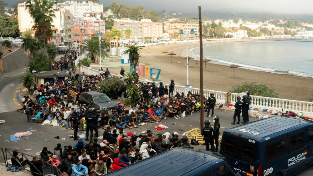 Police escort migrants from Benitez Beach to be relocated to the camp set up at the port of Ceuta, Spain, September 18, 2026. REUTERS/ Anna Surinyach