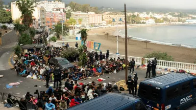 Police escort migrants from Benitez Beach to be relocated to the camp set up at the port of Ceuta, Spain, September 18, 2026. REUTERS/ Anna Surinyach