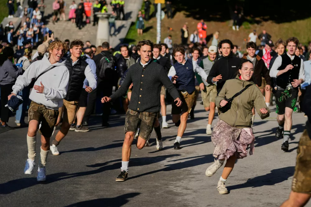 People run to enter the 191st Oktoberfest beer festival in Munich, Germany, Saturday, Sept.19, 2026. (AP Photo/Matthias Schrader)
