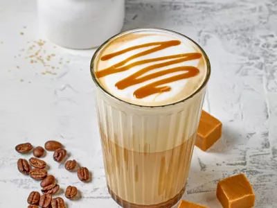 closeup of caramel latte coffee glass on white table background / Foto: Magone Getty Images