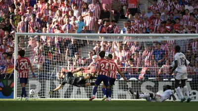 Real Madrid's Antonio Rudiger, on the ground, scores his side's first goal past Atletico Madrid's goalkeeper Jan Oblak during a Spanish La Liga soccer match between Atletico Madrid and Real Madrid in Madrid, Sunday, Sept. 20, 2026. (AP Photo/Bernat Armangue)