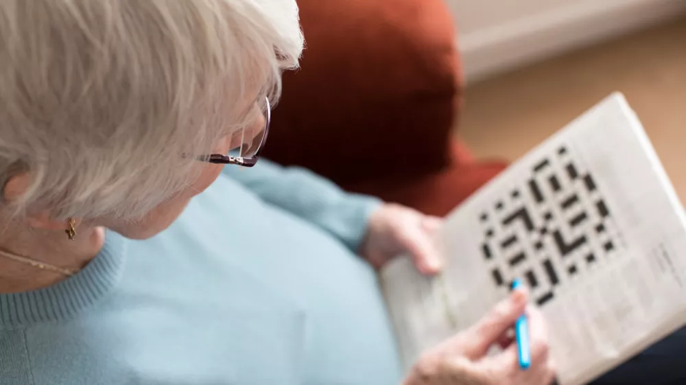 Senior Woman Doing Crossword Puzzle At Home