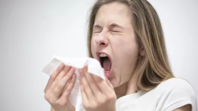young woman sneezing