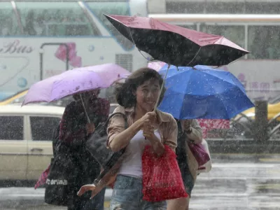 People hold their umbrellas while walking against strong winds caused by Typhoon Dujuan in Taipei, Taiwan, September 28, 2015. REUTERS/Pichi Chuang
