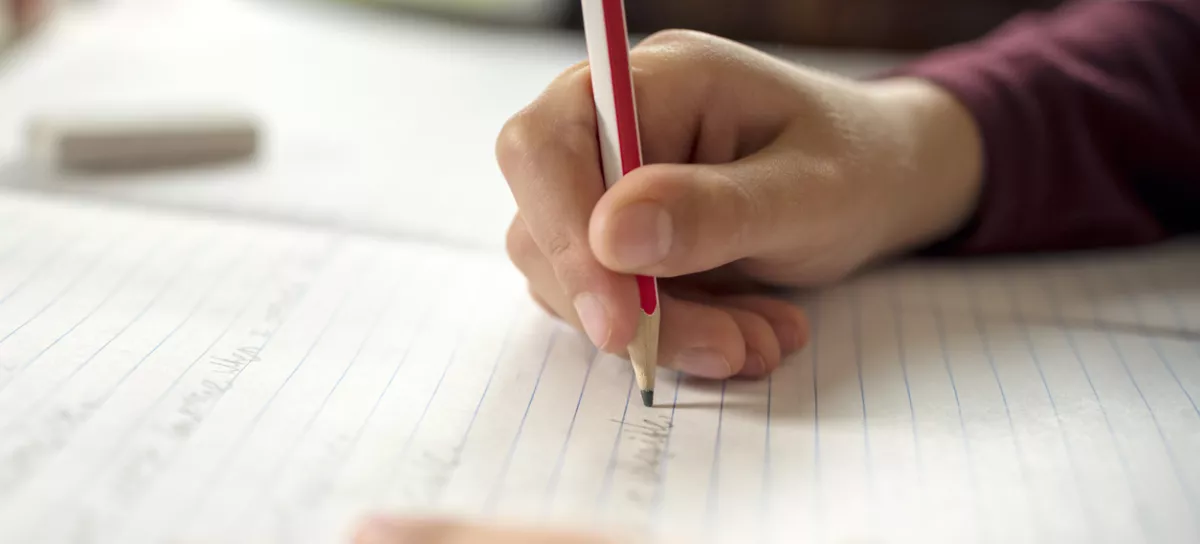 Boy writing in a notepad doing his school work spelling or homework / Foto: Brianajackson Getty Images