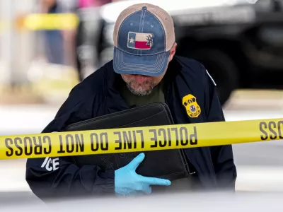 An Immigration and Customs Enforcement officer walks the scene where a man was shot in his vehicle by an ICE officer, Sunday, Sept. 20, 2026, in Austin, Texas. (Aaron E. Martinez /Austin American-Statesman via AP)