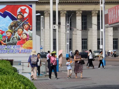 People walk in the street of the Central District in Pyongyang, North Korea, Monday, June 22, 2026. The poster reads, "Let us make strenuous efforts for the prosperity of our great state!" (AP Photo/Jon Chol Jin)