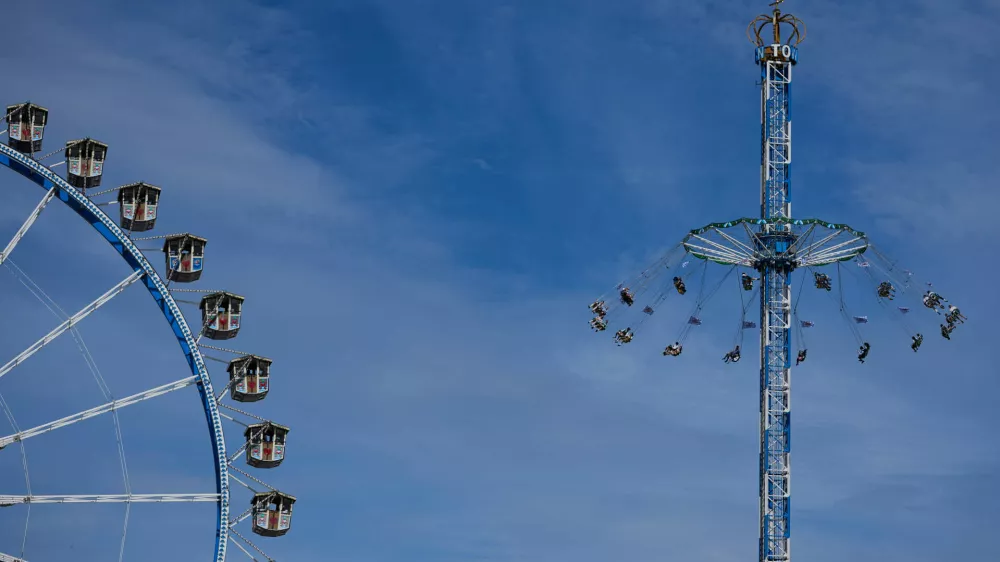 People ride a swing besides a ferris wheel at the 191st Oktoberfest beer festival in Munich, Germany, Sunday, Sept. 20, 2026. (AP Photo/Matthias Schrader)