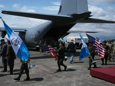 Soldiers carry Guatemalan and U.S. flags as they prepare for a ceremony to receive purchased U.S. military equipment after more than 40 years of a U.S.-imposed arms embargo on Guatemala over human rights violations in Guatemala City, Monday, Sept. 21, 2026. (AP Photo/Moises Castillo)