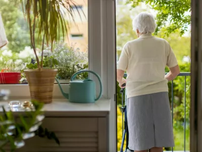 Rear view of a senior woman with walking frame at home / Foto: Piksel