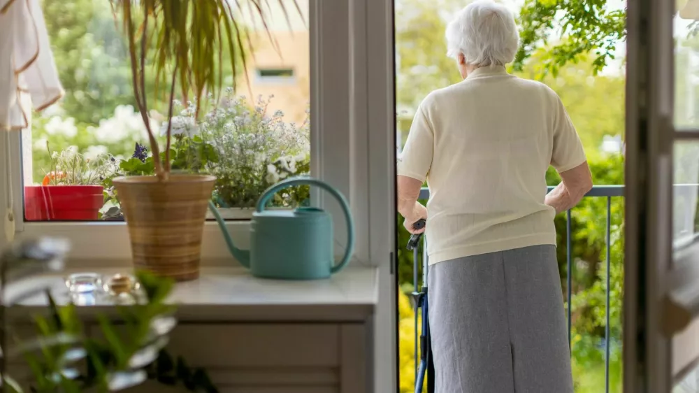 Rear view of a senior woman with walking frame at home / Foto: Piksel