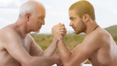 Intense arm wrestling match between elder and younger bare-chested men / Foto: Giulio Fornasar