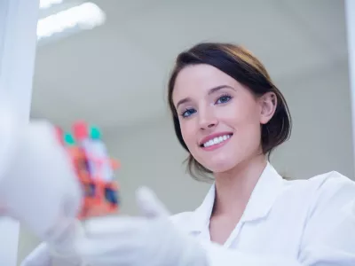 Young female biologist smiling at the camera in hospital / Foto: Wavebreakmedia Getty Images