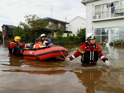 Firefighters transport an elderly woman by boat from a flooded area after Typhoon Dujuan brought torrential rain to Sakura, Chiba prefecture, Japan, September 22, 2026. REUTERS/Kim Kyung-Hoon