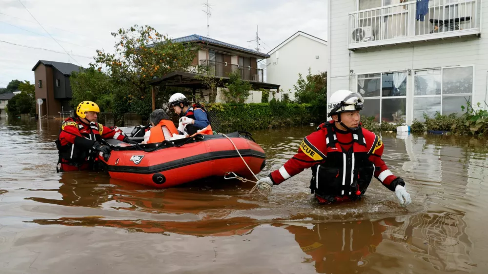 Firefighters transport an elderly woman by boat from a flooded area after Typhoon Dujuan brought torrential rain to Sakura, Chiba prefecture, Japan, September 22, 2026. REUTERS/Kim Kyung-Hoon