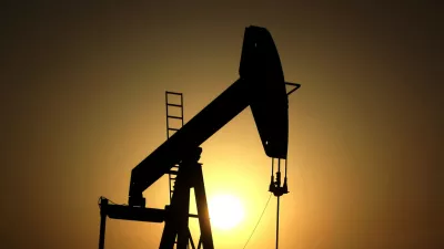 FILE- In this Wednesday, June 8, 2011 file photo, sun sets behind an oil pump in the desert oil fields of Sakhir, Bahrain. (AP Photo/Hasan Jamali, File)