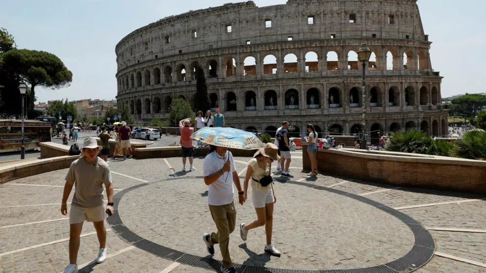 FILE PHOTO: A person holds an umbrella as people walk near the Colosseum during a heatwave across Italy, as temperatures are expected to rise further in the coming days, in Rome, Italy August 3, 2026. REUTERS/Remo Casilli/File Photo
