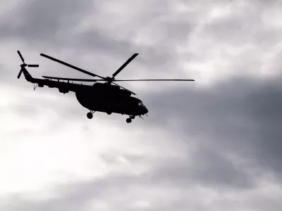 Silhouette of S Soviet helicopter Mi-8 common operational military aircraft aloft in the air cloudy sky